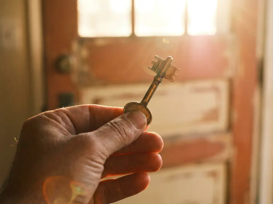 A set of house keys resting on a wooden doorframe threshold